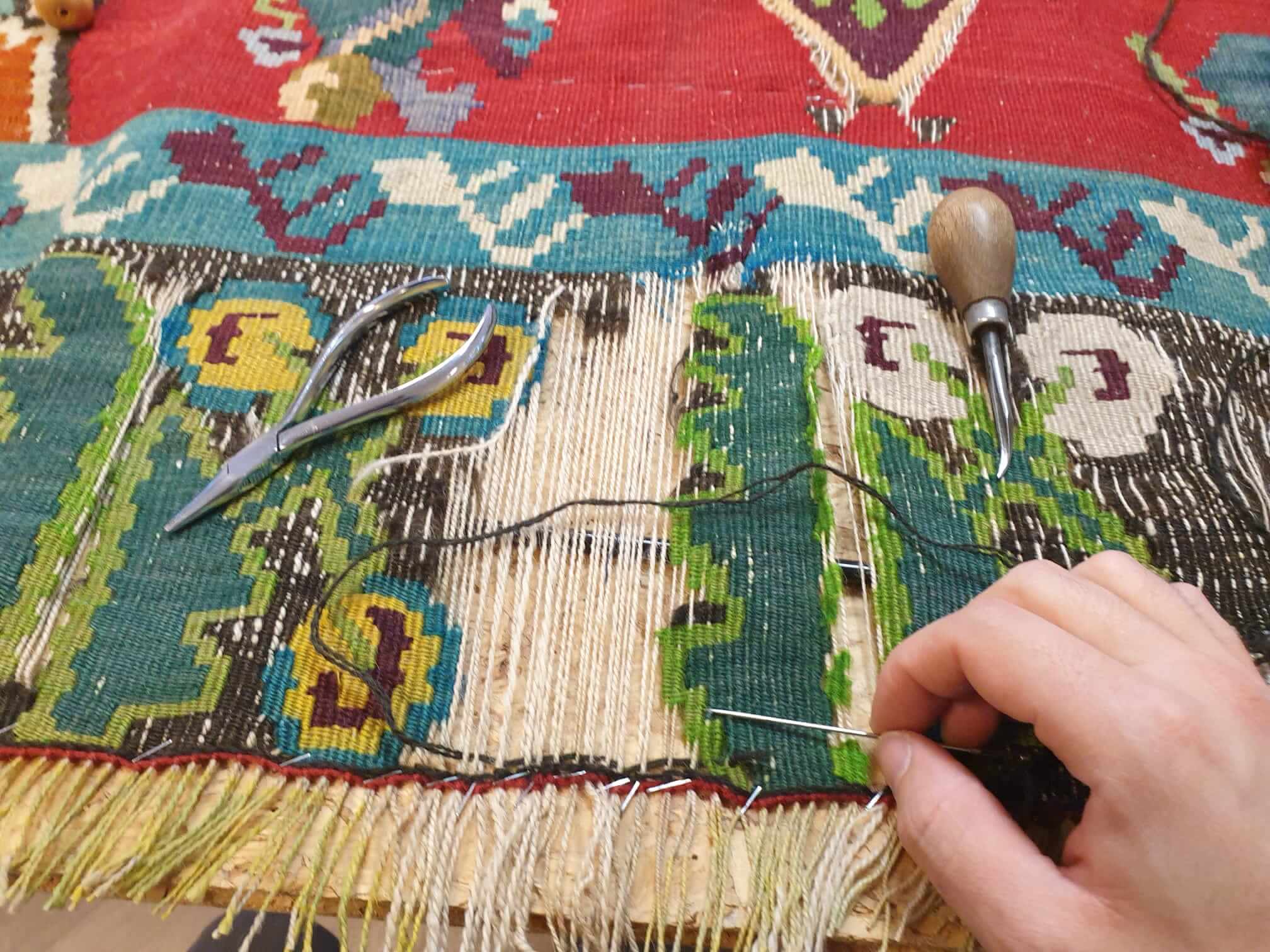 Herstel van een handgeknoopt tapijt in het atelier van Heriz Tapijten